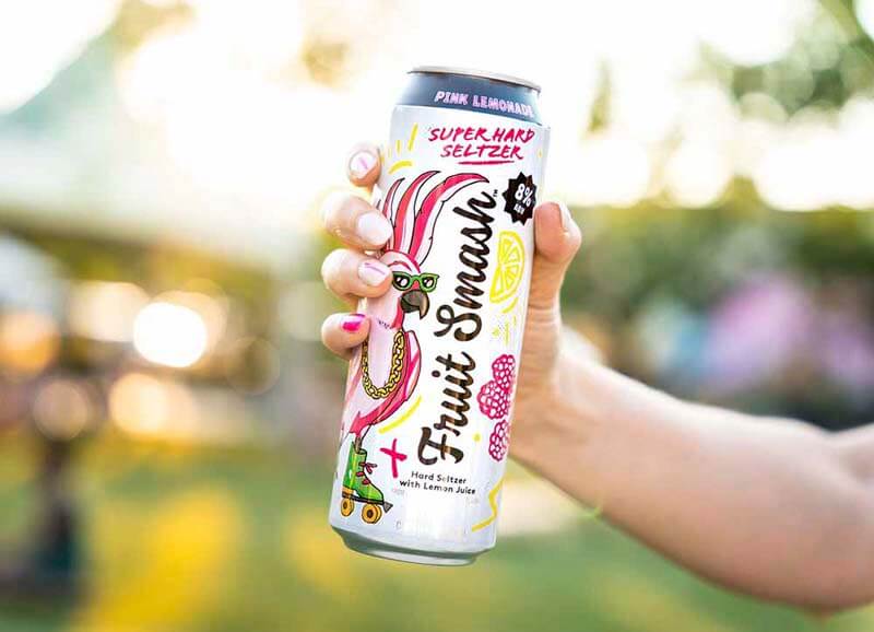A hand holding a tall can of Fruit Smash, a high ABV super hard seltzer from New Belgium Brewing Co.