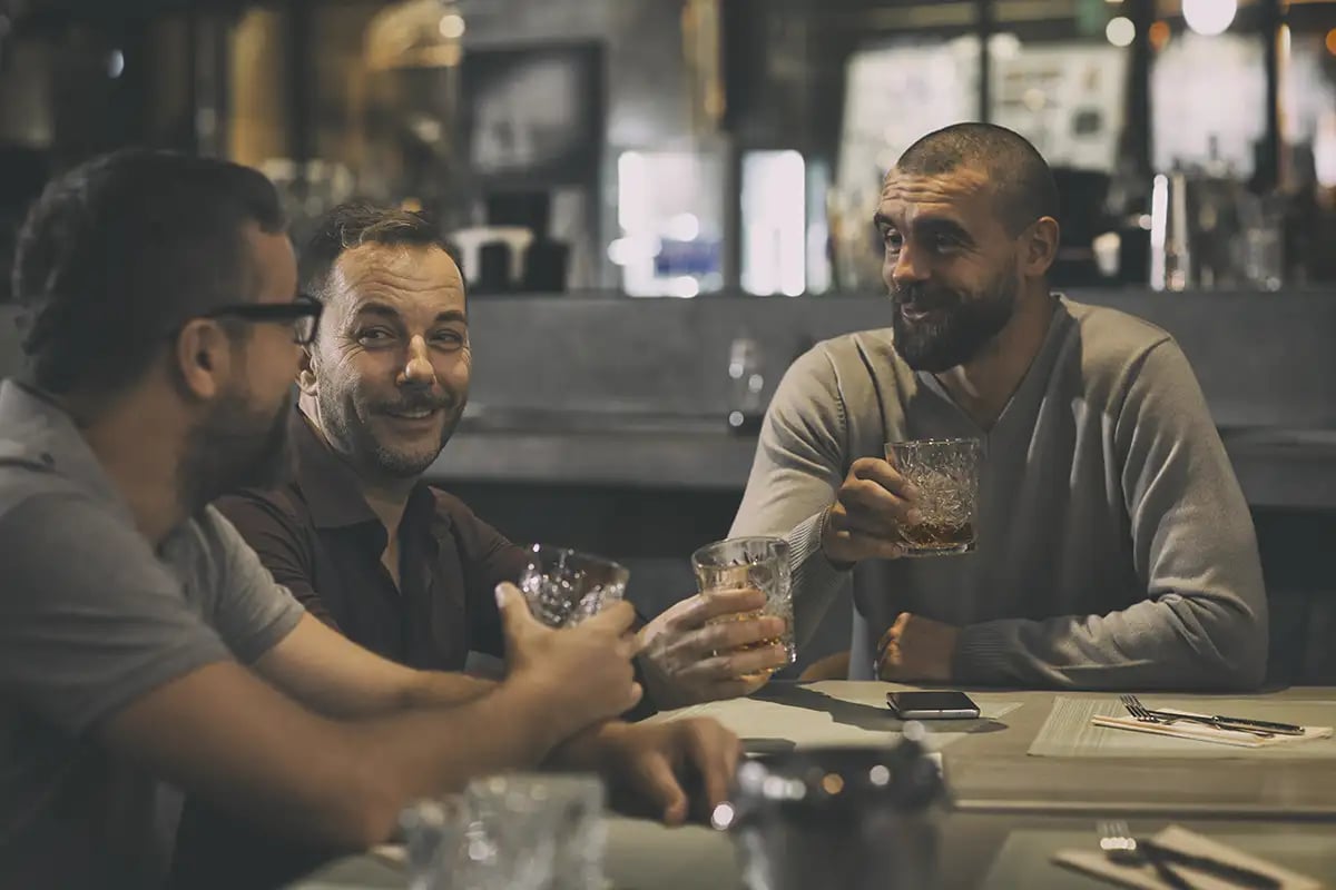 A group enjoys whiskey at a table