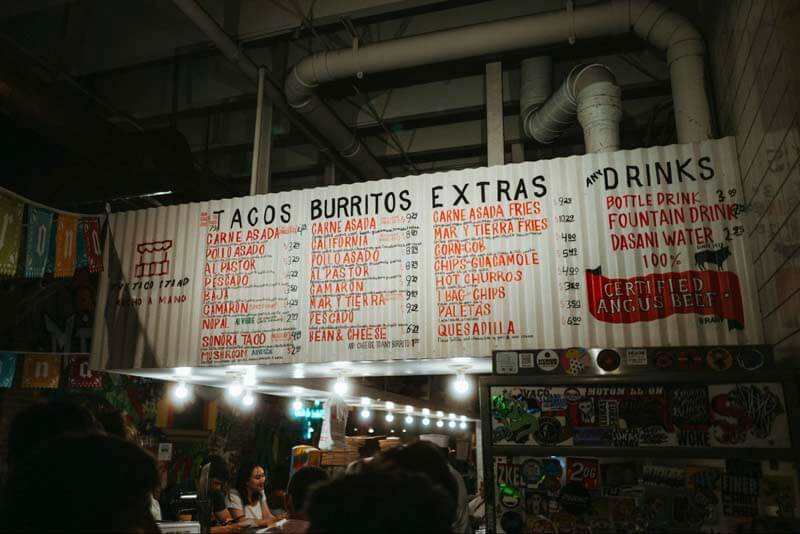 A food menu above a bar designed on recycled sheet metal