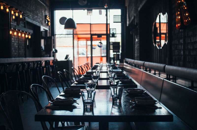 A row of empty tables at a restaurant before opening