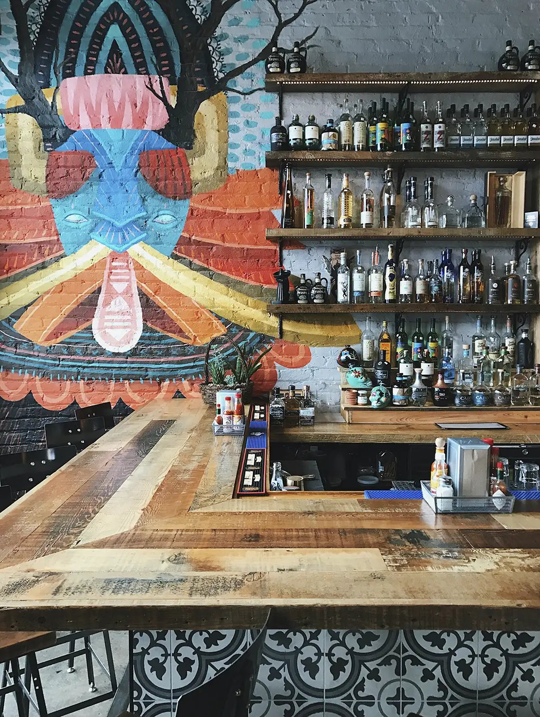 A variety of tequila bottles behind a Mexcian-themed bar
