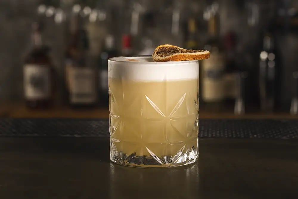 A whiskey sour cocktail on a bar