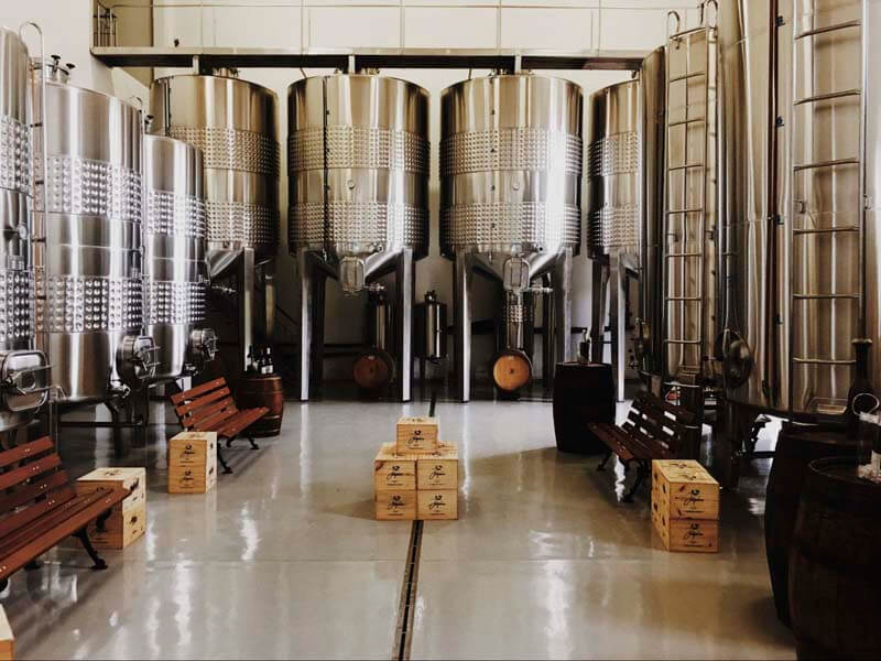 Clean backroom of brewery with shiny tanks and shimmering floor