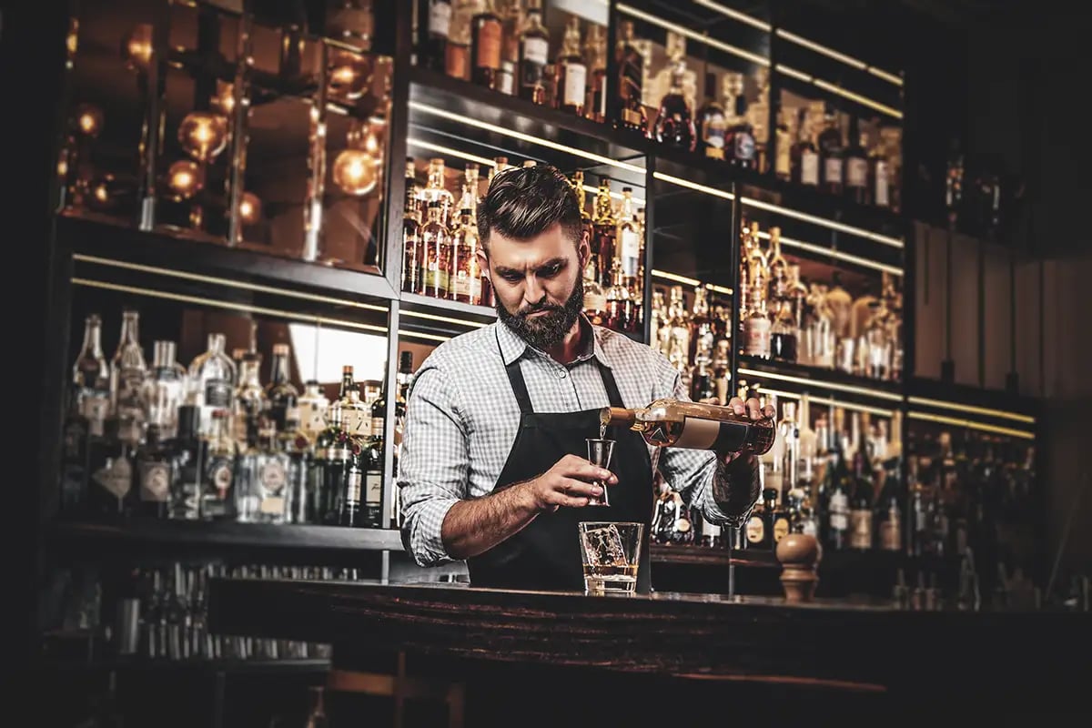 A bartender makes a whiskey cocktail