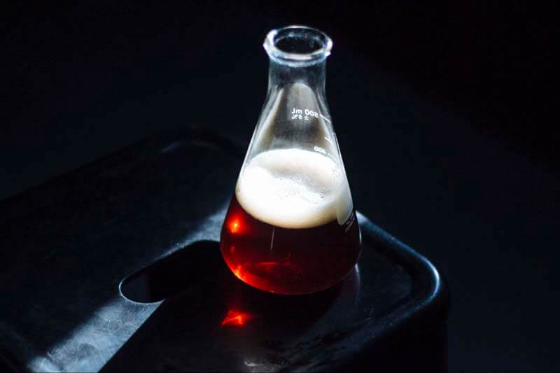Beer in a beaker shot from a high angle in a dark room