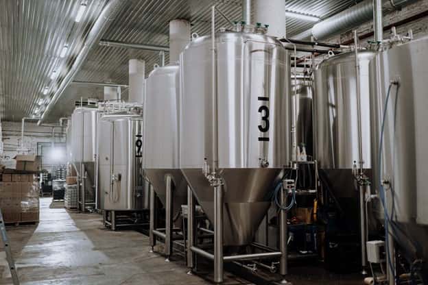 Row of stainless steel brew tanks or fermenters in a brewery