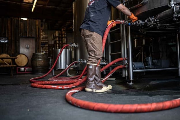 Brewer connecting hoses while wearing XTRATUF Legacy boots