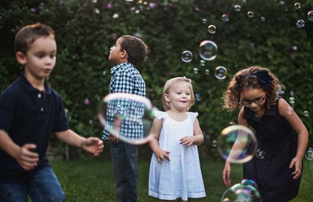 Children playing with bubbles outside