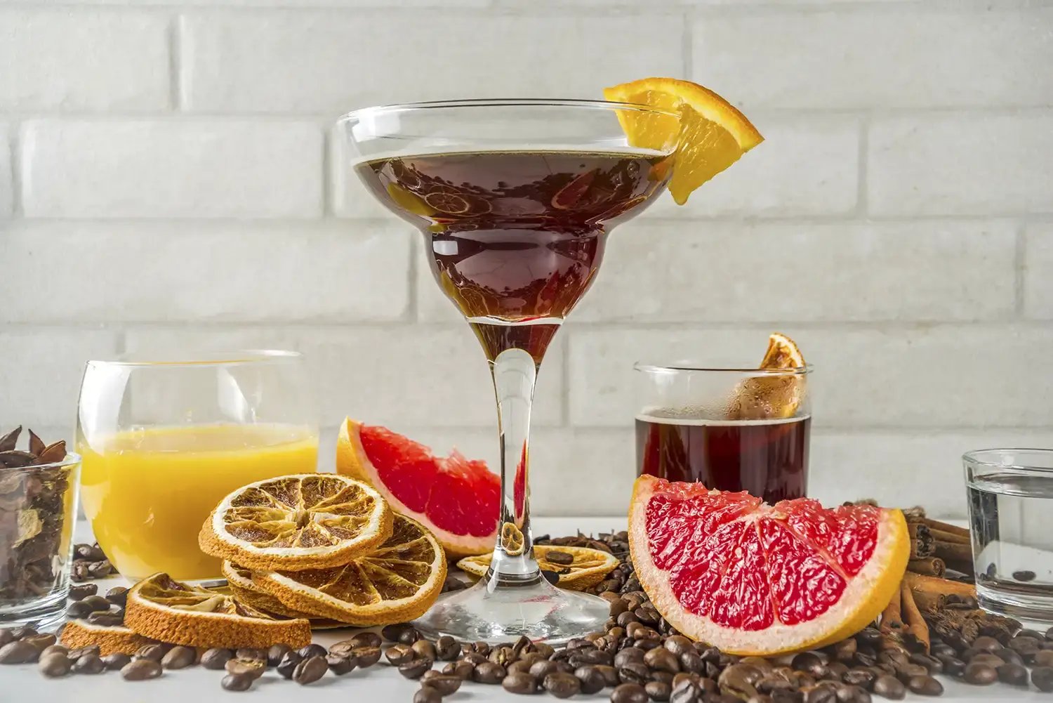 A photo of a coffee negroni coffee cocktail with oranges and coffee beans