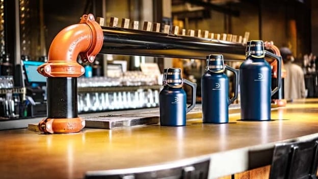 Various sized DrinkTanks crowlers sitting on bar counter