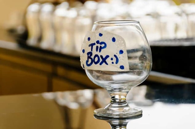 Glass tip jar on bar counter