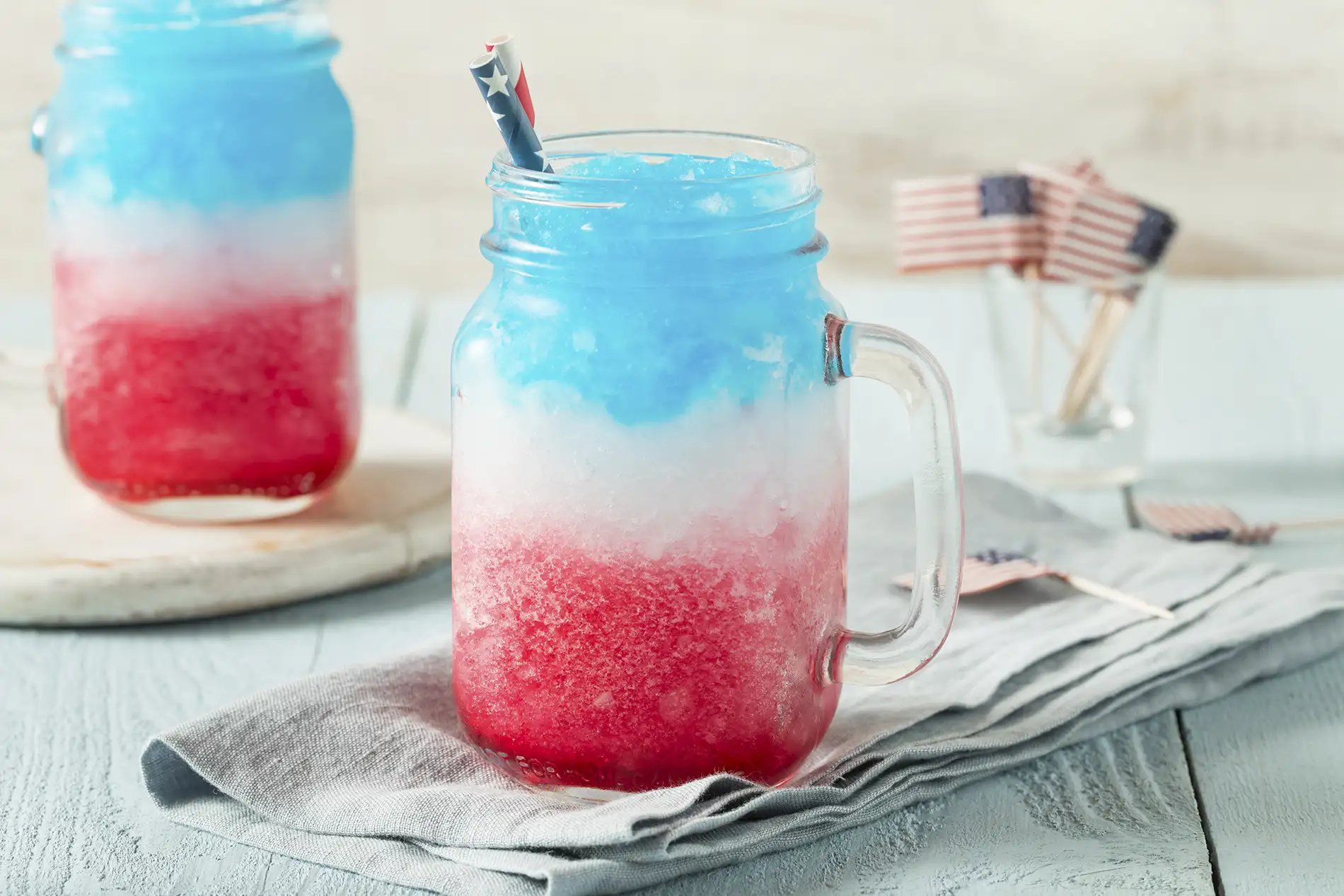 A red, white, and blue inspired frozen margarita for the 4th of July served in a mason jar