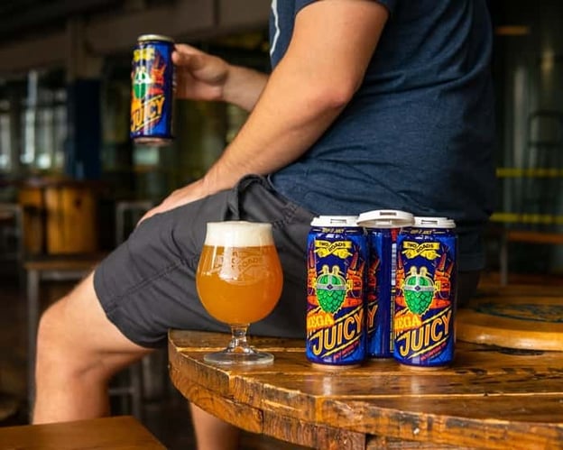 Mega Juicy beer cans on bar table from Two Roads Brewing Company