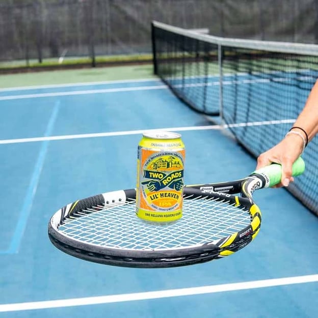 Two Roads Brewing Company Lil' Heaven beer can on a tennis racket