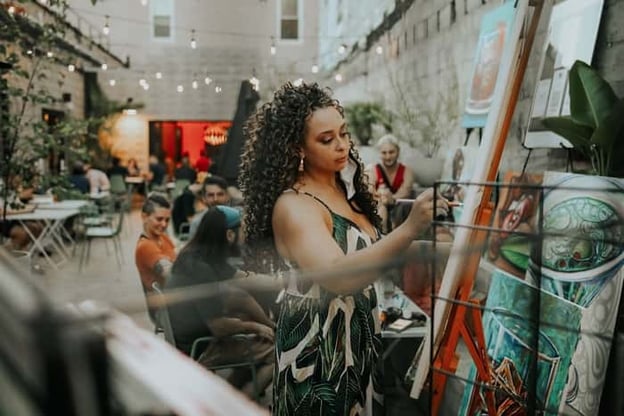 Woman doing a live painting outdoors at Trace Brewing