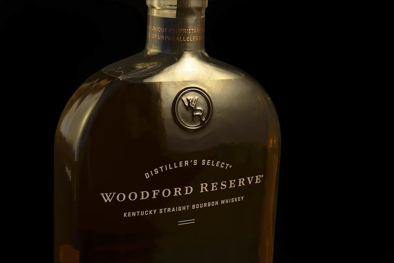 A bottle of Woodford Reserve bourbon on a black background